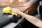 A man cleaning white car with yellow microfiber cloth.