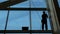 Man is cleaning windows on a highrise building.