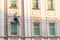 Man cleaning windows and wall on old city bulding