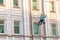 Man cleaning windows and wall on old city bulding