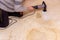 A man cleans a dirty mattress with an electric brush.