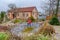 A man cleans a garden pond with a landing net from slime, water plants, falling leaves and catches fish