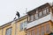 A man cleans the roof of the house of accumulated snow