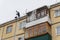 A man cleans the roof of the house of accumulated snow