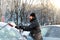 Man cleans snow from the glass at the car