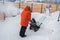A man clear snow from backyard with snow blower. Winter season and snow blower equipment