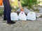 The man cleared the park and the beach from debris. He is holding bags of trash and plastic. The concept of teaching children to