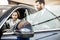 Man client with salesperson choosing car in the showroom