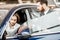 Man client with salesperson choosing car in the showroom