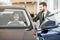 Man client with salesperson choosing car in the showroom