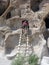 Man climbing ladder at cliff dwellings