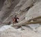 Man climbing steep ladder at cliff dwellings