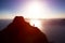 Man climbing up hill to reach the peak of the mountain over ocean.