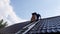 a man climbs a metal ladder to the roof of the bathhouse to clean the pipe from soot and soot