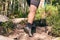 Man climbs in sneakers in outdoor action. Top View of hiking Boot on the trail. Close-up Legs In Jeans And sport trekking shoes on