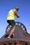 Man climbs to the top of disused crusher wheel