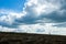 Man climbs up the hill. Mountain climbing. Hiking. Impressive skies