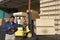 Man With Clipboard In Front Of Forklift Stacking Boxes