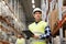 Man with clipboard in safety vest at warehouse