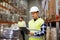 Man with clipboard in safety vest at warehouse