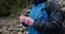 A man, close-up portrait, takes a photo of a landscape with a small camera