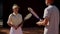 A man coach and the girl ward stand on the sports field after joint training and exchange opinions on shortcomings and