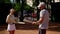 A man coach and the girl ward stand on the sports field before the start of a joint training session and exchange