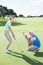 Man coaching his partner on the putting green