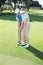 Man coaching his partner on the putting green