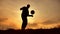 Man coins a ball European the football soccer freestyle silhouette at outdoors sunset sunlight. man beats chasing ball