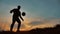 Man coins a ball European the football soccer freestyle silhouette at sunset sunlight. man beats chasing ball outdoors