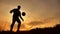 Man coins a ball European the football soccer freestyle silhouette at sunset sunlight. man beats chasing outdoors ball