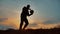 Man coins a ball European the football soccer freestyle silhouette at sunset sunlight. man outdoors beats chasing ball
