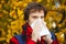 Man with cold rhinitis on autumn background. Fall flu season. Il