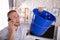 Man Collecting Water Leakage In Bucket While Calling Plumber