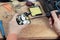 A man collects radio components. He puts it on the board and soldering it with a soldering iron. Assembly of the