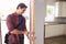 Man Coming Home From Work And Opening Door Of Apartment