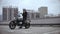 Man coming to motorbike and wearing helmet on top of the multi-level parking