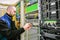 A man commutes Internet wires in a server rack. The system administrator works in the server room of the data center. An engineer