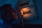 Man in complete darkness holding a candle to investigate a home fuse box during a power outage. Blackout concept