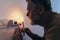 Man in complete darkness holding a candle to investigate thermostat during a power outage. Blackout concept