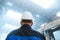 Man in a construction helmet on a background of industrial production. Worker inspects the facility and checks the progress of