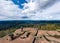 A man controls a drone standing on top of a cliff. Around the autumn mountain landscape. Vosges, Alsace