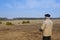 A man controls a radio-controlled aircraft on the field in early spring