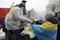 Man cook giving food from the field stove to woman, people standing in a line. Tent town, Revolution of Dignity. Kyiv