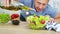 Man cook pouring olive oil into the fresh vegetable salad in his kitchen. Slow motion video shot on Black Magic Cinema