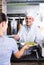 Man cook serving fresh kebab dish to customer on counter in fast