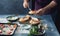 Man cooking bruschetta with baked tomato, cheese and garlic