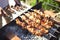 Man cooking marinated shashlik, lamb meat grilling on metal skewer