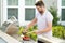 Man cooking meat on barbecue in the backyard of the house. Handsome man preparing barbecue. Barbecue chef master. Cook